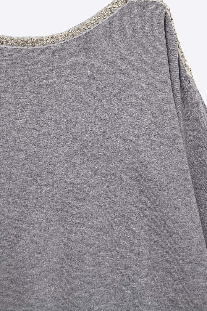 grey fine knit sweater with a boat neck and rhinestone detail