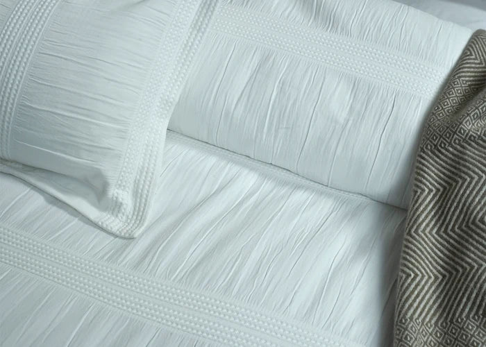 White textured duvet cover with subtle jacquard pattern and ruched panel