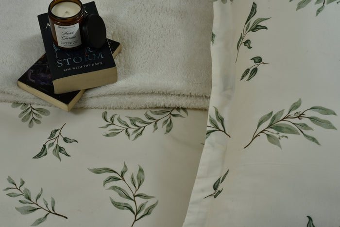 Cotton sateen fitted sheet corner with green botanical leaf pattern