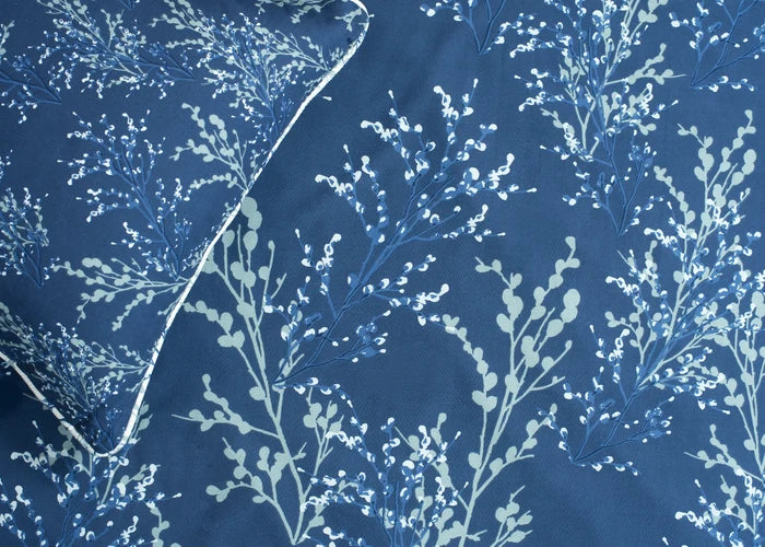 Navy cotton bed sheet with white tree branch pattern, corner view