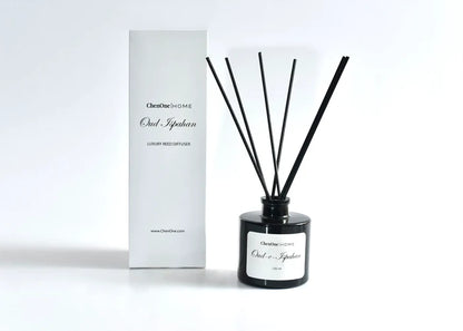 Black reed diffuser with dark reeds and white boxed packaging