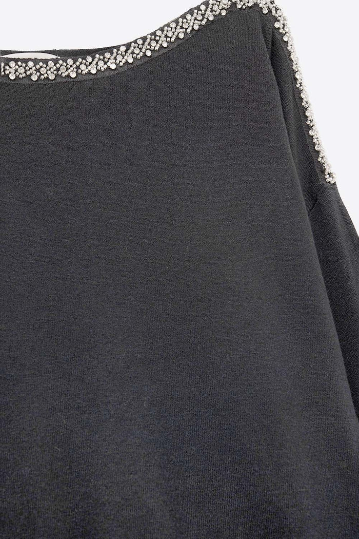black fine knit sweater with a boat neck and rhinestone detail