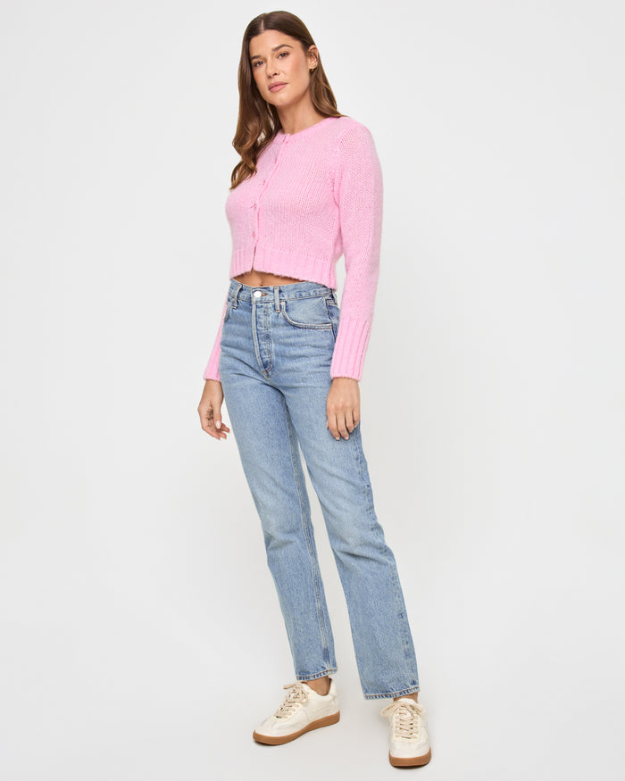 Three-quarter view of a model wearing the LSPACE Brynn Cardigan in rosewater, showing the cropped fit and button-front detail.