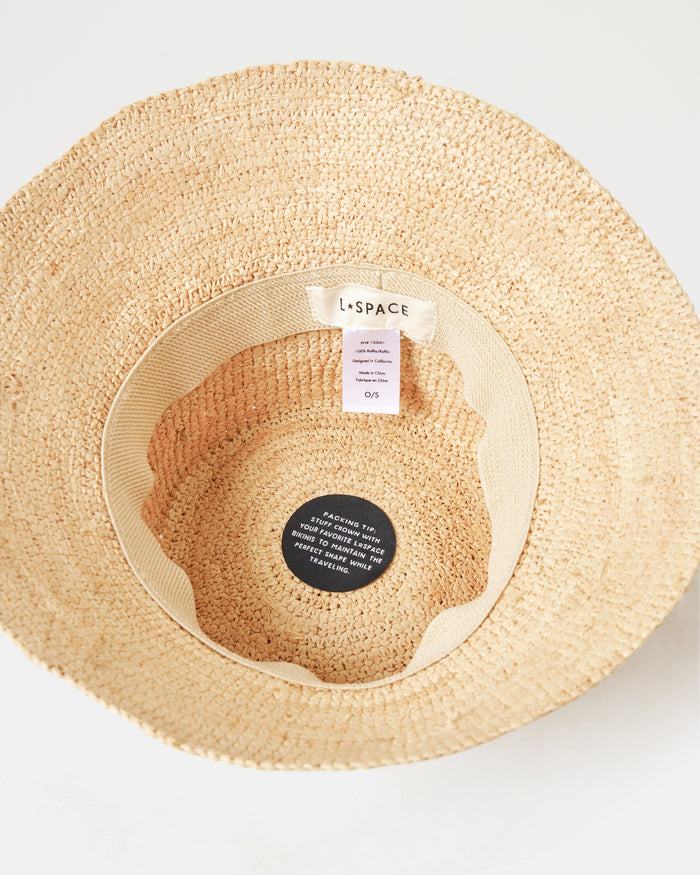 Top-down interior view of the Carmel Island Hat in natural showing the LSPACE branding label and packing tip tag.