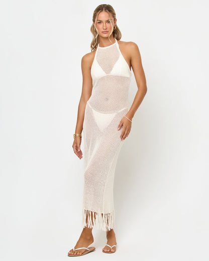 Front view of a model wearing the LSPACE Caught By Sea Cover-Up in cream on a white background, showing the halter neckline, sheer crochet maxi body, fringe hem, and cream bikini top visible underneath.