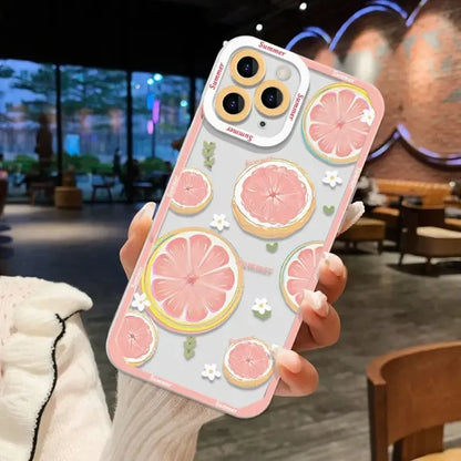 a woman holding up a phone case with a pink grape pattern