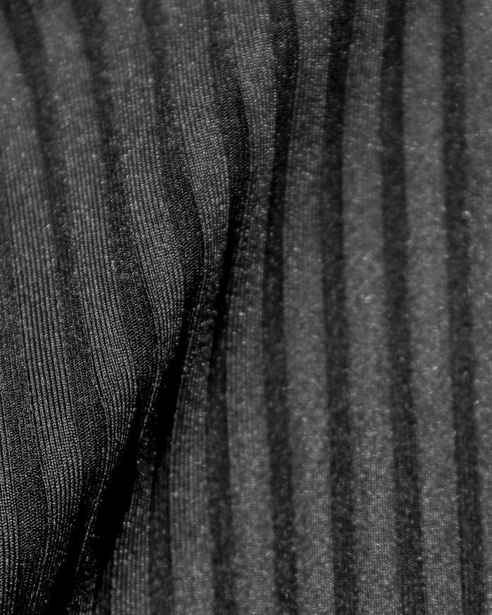 Close-up detail of the black ribbed eco-friendly fabric texture of the LSPACE Effie Bikini Top, off-model.