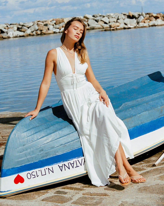 LSPACE Emmaline maxi dress in cream, lifestyle/editorial view on model seated on a boat.