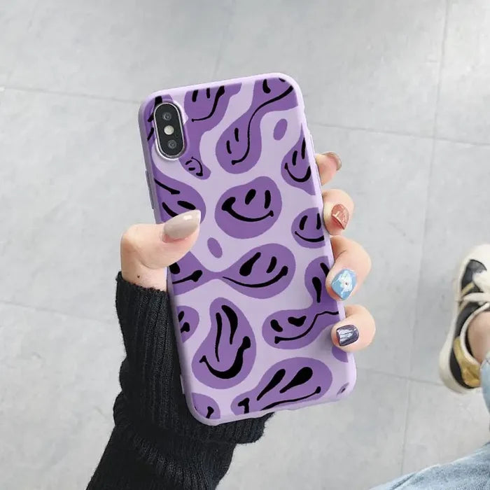 a purple and black phone case with a smiley face pattern