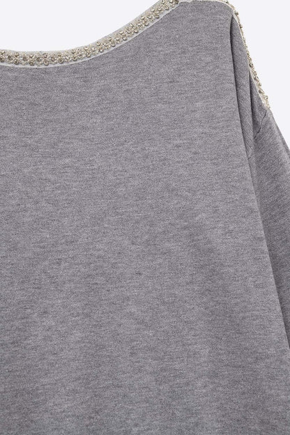 grey fine knit sweater with a boat neck and rhinestone detail