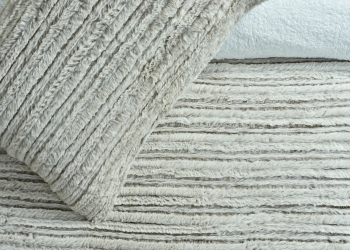 Brushed striped bedding fabric detail on comforter and blanket layers