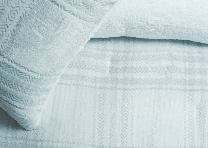 Light grey carved bedding fabric detail on duvet with textured geometric pattern