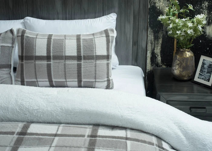 Grey plaid pillow sham and plush grey comforter on bed