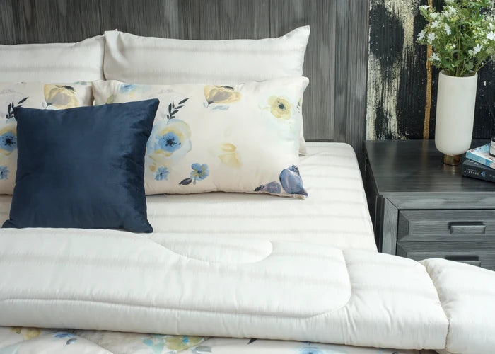 Cream comforter set with navy and floral decorative pillows