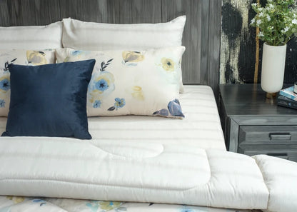 Cream comforter set with navy and floral decorative pillows