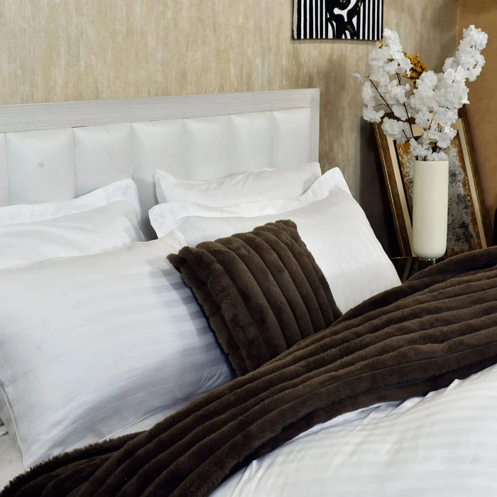 White duvet cover with dark brown corded blanket and textured brown pillows