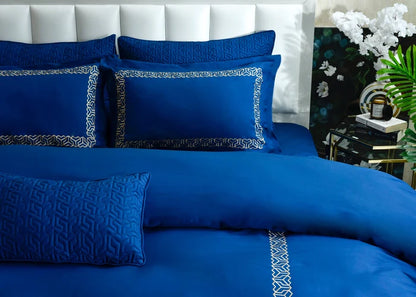 Cobalt blue duvet cover set with embossed pattern, matching shams, and piped trim