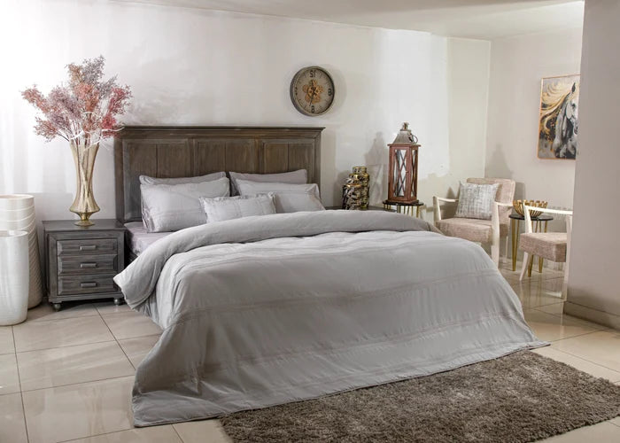 Grey duvet cover set with matching pillow shams and pillows on a bed