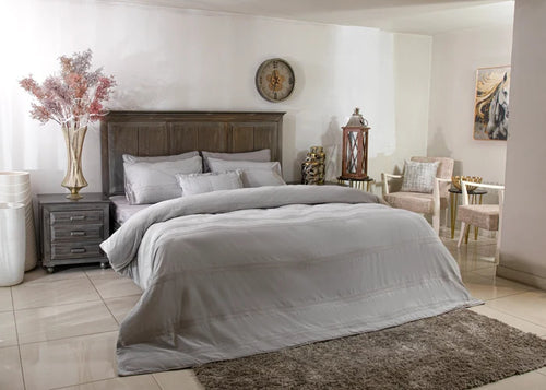 Grey duvet cover set with matching pillow shams and pillows on a bed