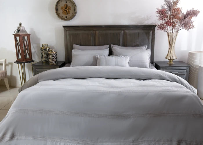 Grey duvet cover with smooth fabric texture and stacked pillow shams