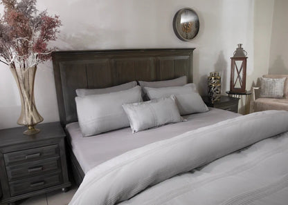 Grey duvet cover set featuring pillow shams and decorative pillows on the bed
