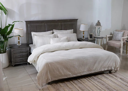Off-white striped duvet cover with layered pillows on a bed