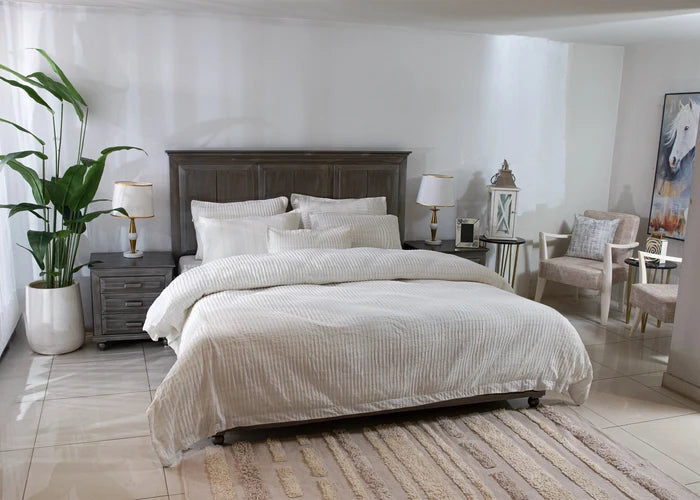 Off-white striped duvet cover set with pillows arranged on a bed