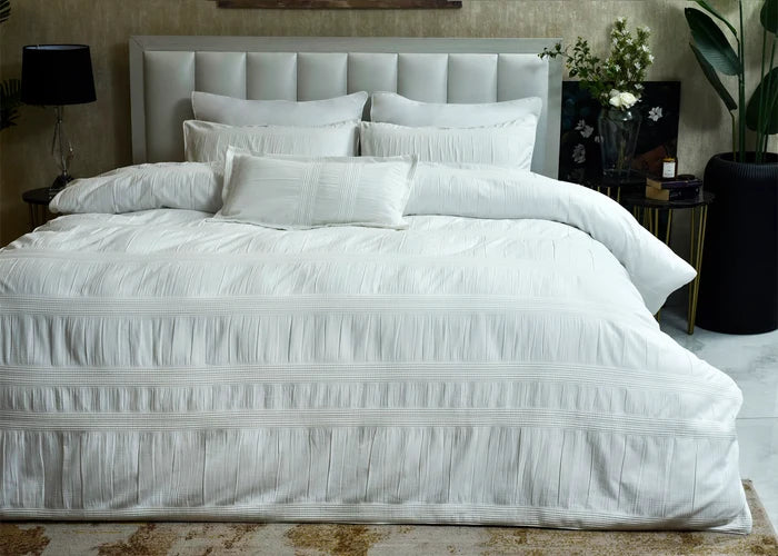 White 7-piece duvet cover set with quilted duvet, matching pillow shams, and pillows