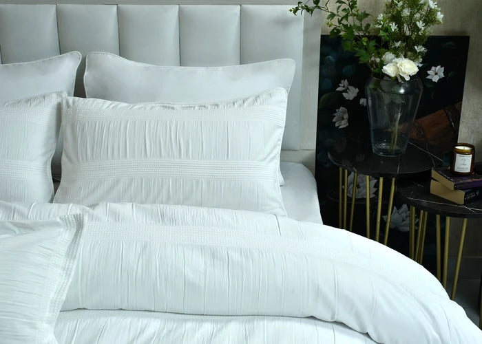 White duvet cover set with pleated cover, decorative stitched edges, and coordinated shams