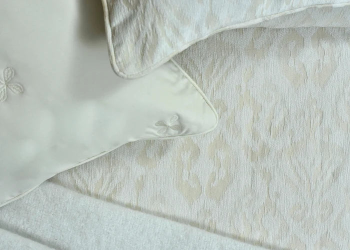 Beige jacquard duvet cover fabric with stitched edge and piping close-up