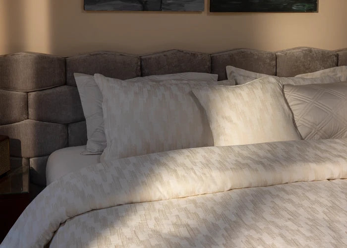 Light beige duvet cover set with square-pattern pillowcases and neatly arranged bed