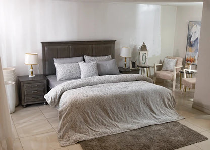 Grey duvet cover set on bed with matching square pillow shams and decorative pillows