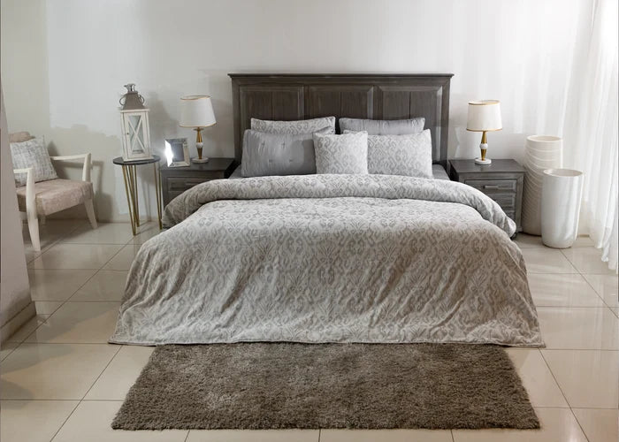 Grey duvet cover set on bed with patterned duvet and matching pillow shams