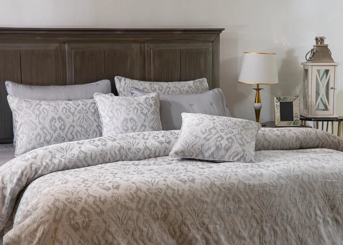 Grey duvet cover set with patterned pillows and square pillow shams, front view