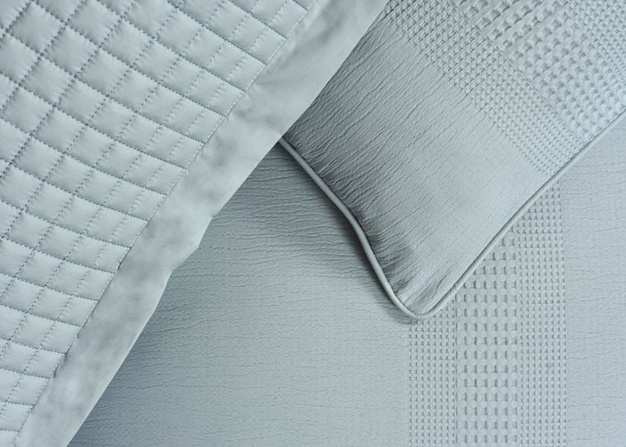 Quilted duvet cover corner with grey textured trim and white fabric surface