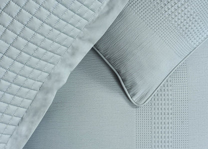Quilted duvet cover corner with grey textured trim and white fabric surface