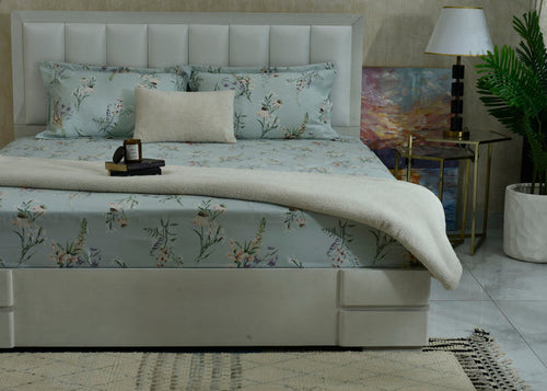 Ice blue cotton sateen bed sheet with botanical floral print on a bed