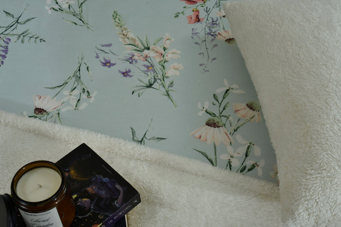 Ice blue cotton sateen bed sheet corner with floral print and textured edge