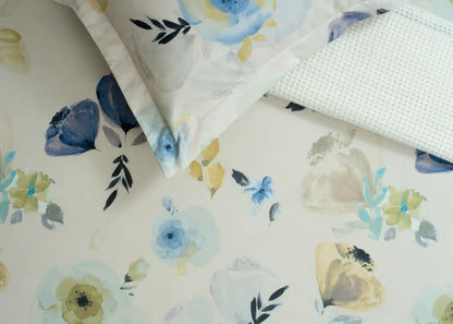Close-up of cream cotton bed sheet fabric with blue and yellow floral design