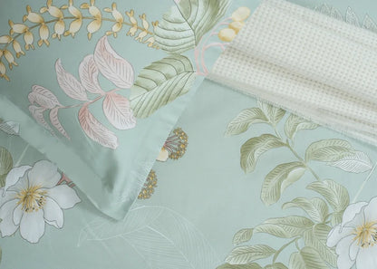 Light green tropical floral bed sheet fabric close-up with leaf and blossom print