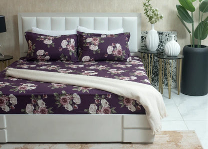 Purple microfiber bed sheet set with rose floral print, draped over bed