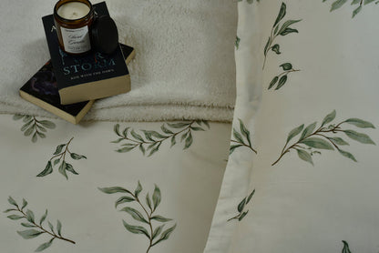 Cotton sateen fitted sheet corner with green botanical leaf pattern