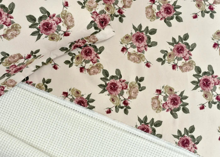 Cream microfiber bed sheet fabric with pink rose floral pattern and stitched edge