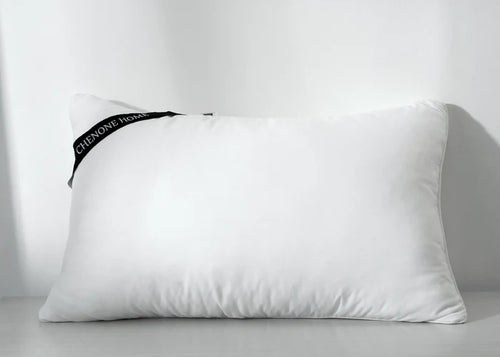 White rectangular compressed pillow with corner seam and side fabric tag