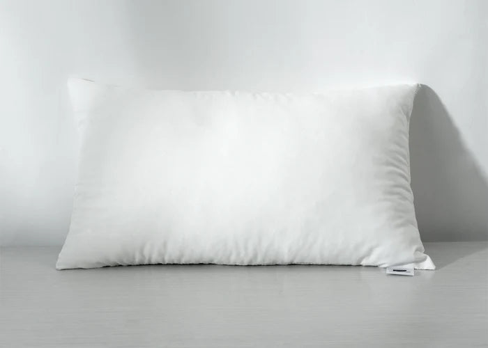 White rectangular compressed pillow, side view with smooth stitched edges