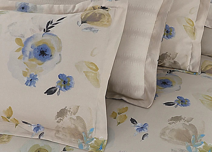 Cream cotton pillow covers with blue blossoms and green accents, stitched border