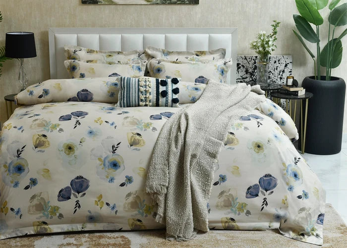 Cotton quilt cover in pale tones with blue and yellow floral print and textured throw