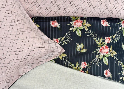 Quilt cover close-up: mauve geometric grid reverse and black floral rose stripe front