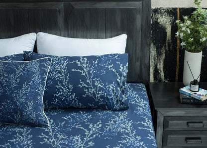 Navy cotton bed sheet with white tree branch pattern, close bed angle