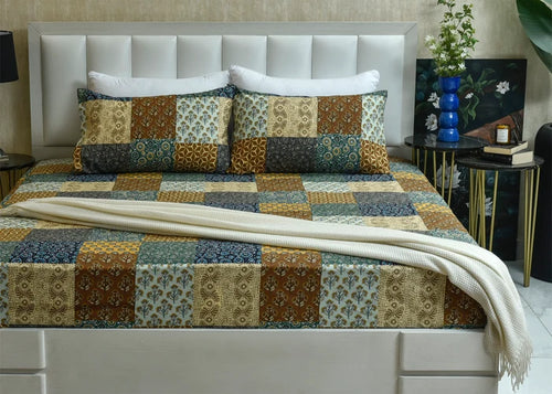 Cotton bed sheet with patchwork geometric and floral blocks in blue, gold, and cream
